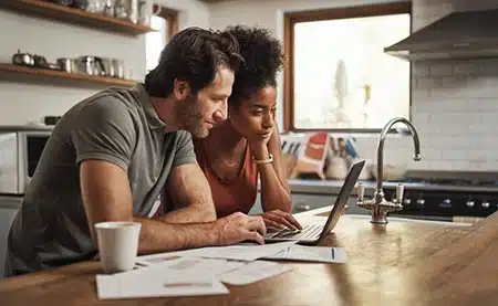 Couple looking at adoption loan paperwork in preparation of adopting